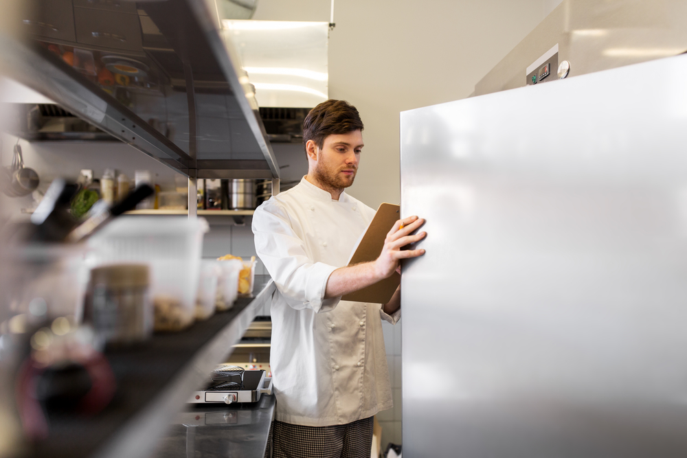 Male Chef checking fridge seals in a commercial kitchen