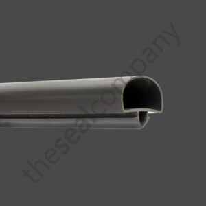 A close-up of the H&K International T03184 Door Gasket Seal, a dark grey rubber seal with a rounded top and channel underneath for edge fitting. The solid grey background features a faint diagonal “thesealcompany” watermark.